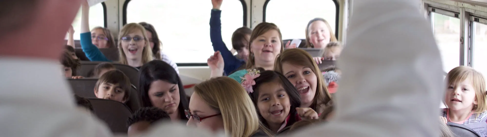 Children smiling on the church bus
