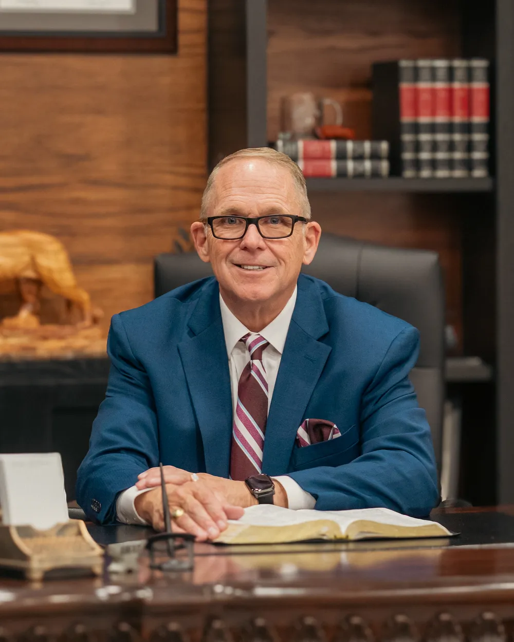 Pastor William Reeves at his desk with an open Bible